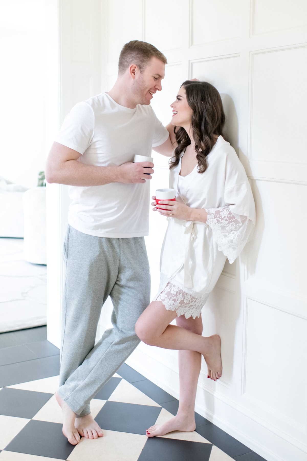 Couple enjoying coffee in pajamas looking lovingly at each other