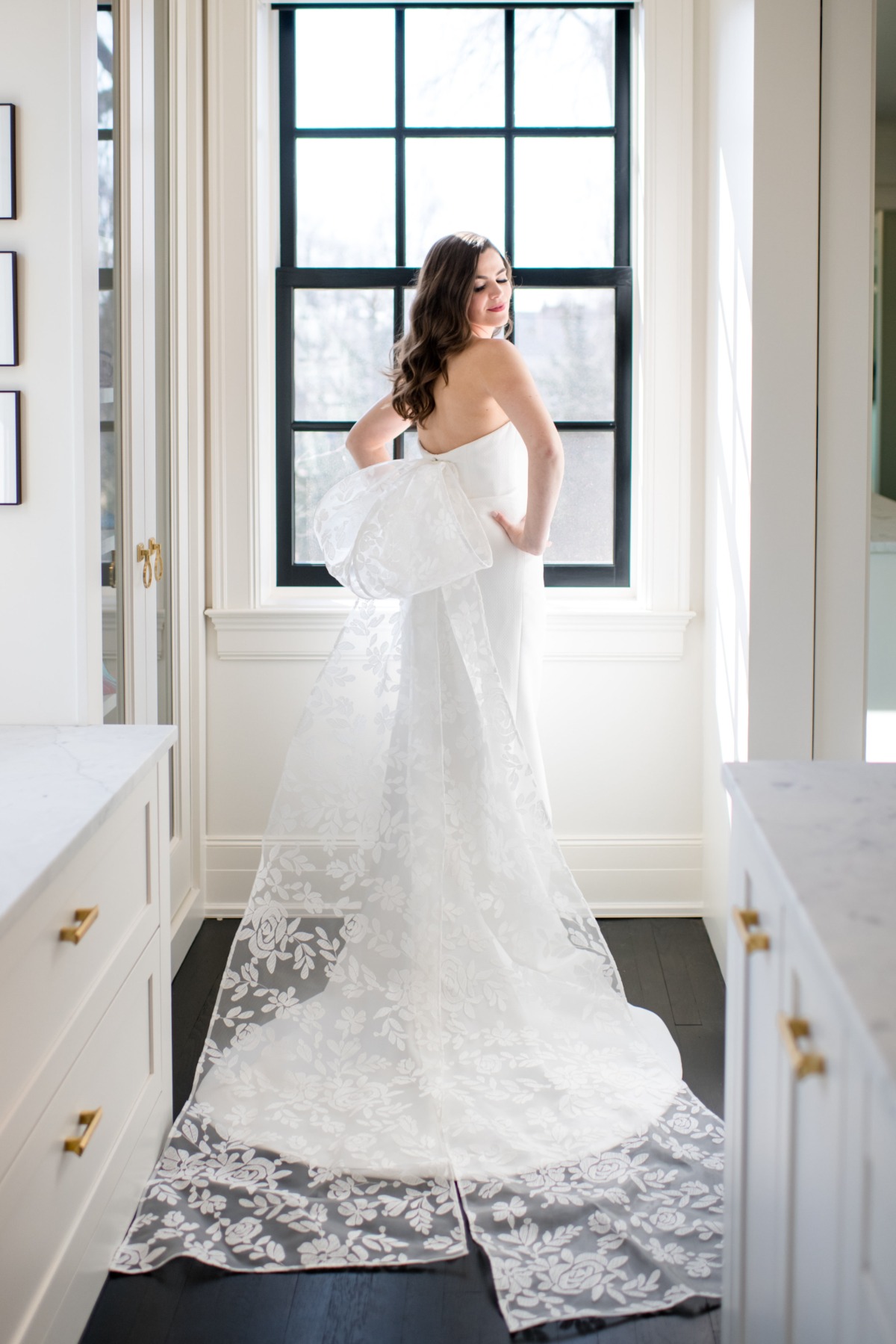 Elegant bride in a white dress with a beautiful bow and train