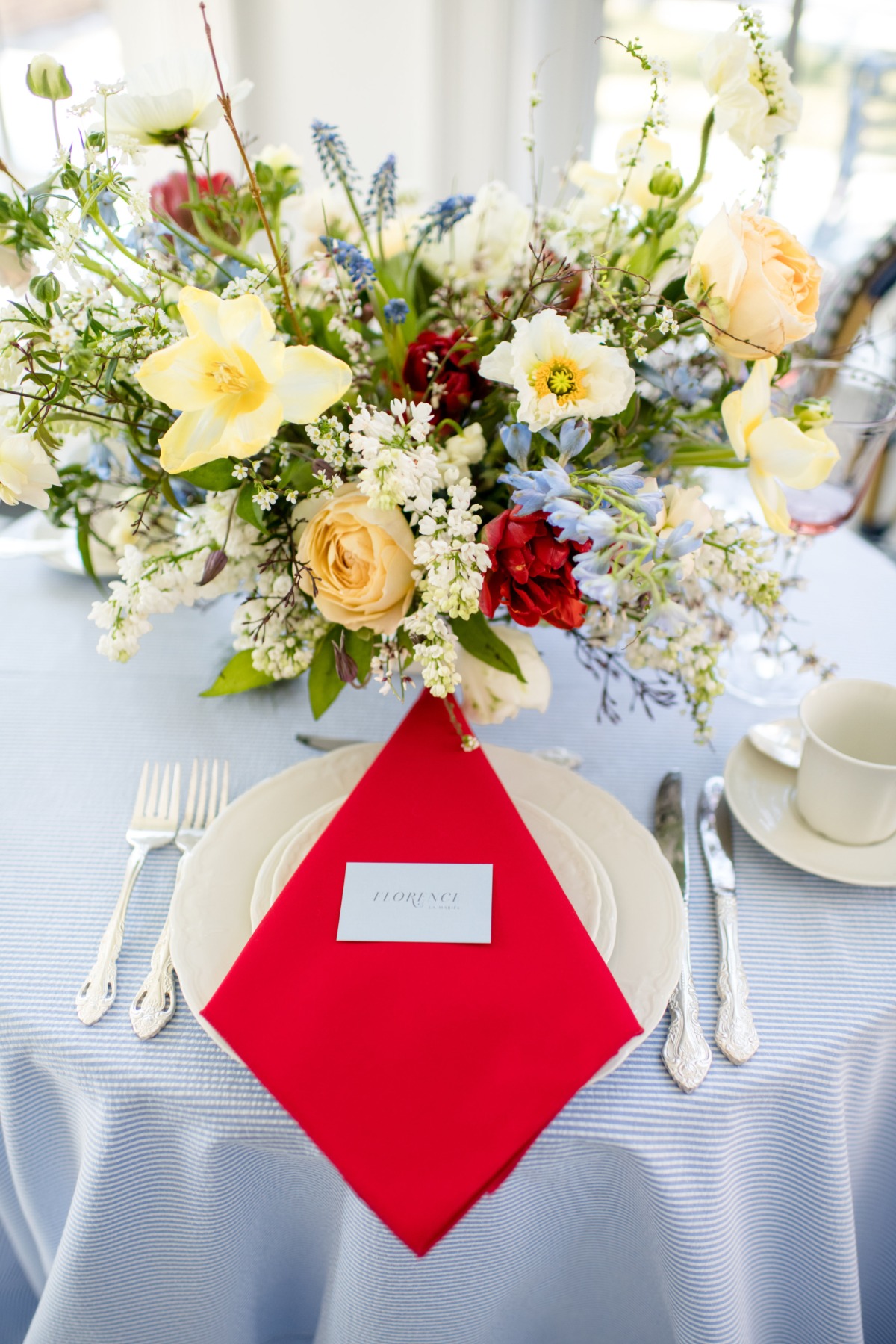 Elegant table setting with vibrant floral centerpiece and red napkin