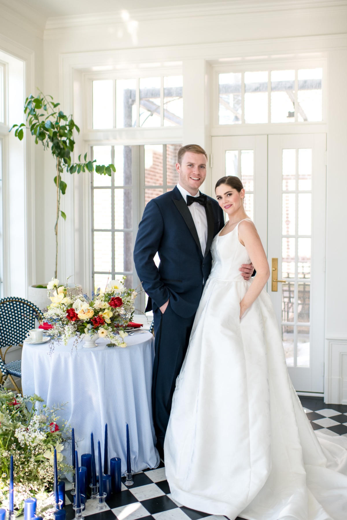 Elegant bride and groom pose for a wedding photo in a bright room