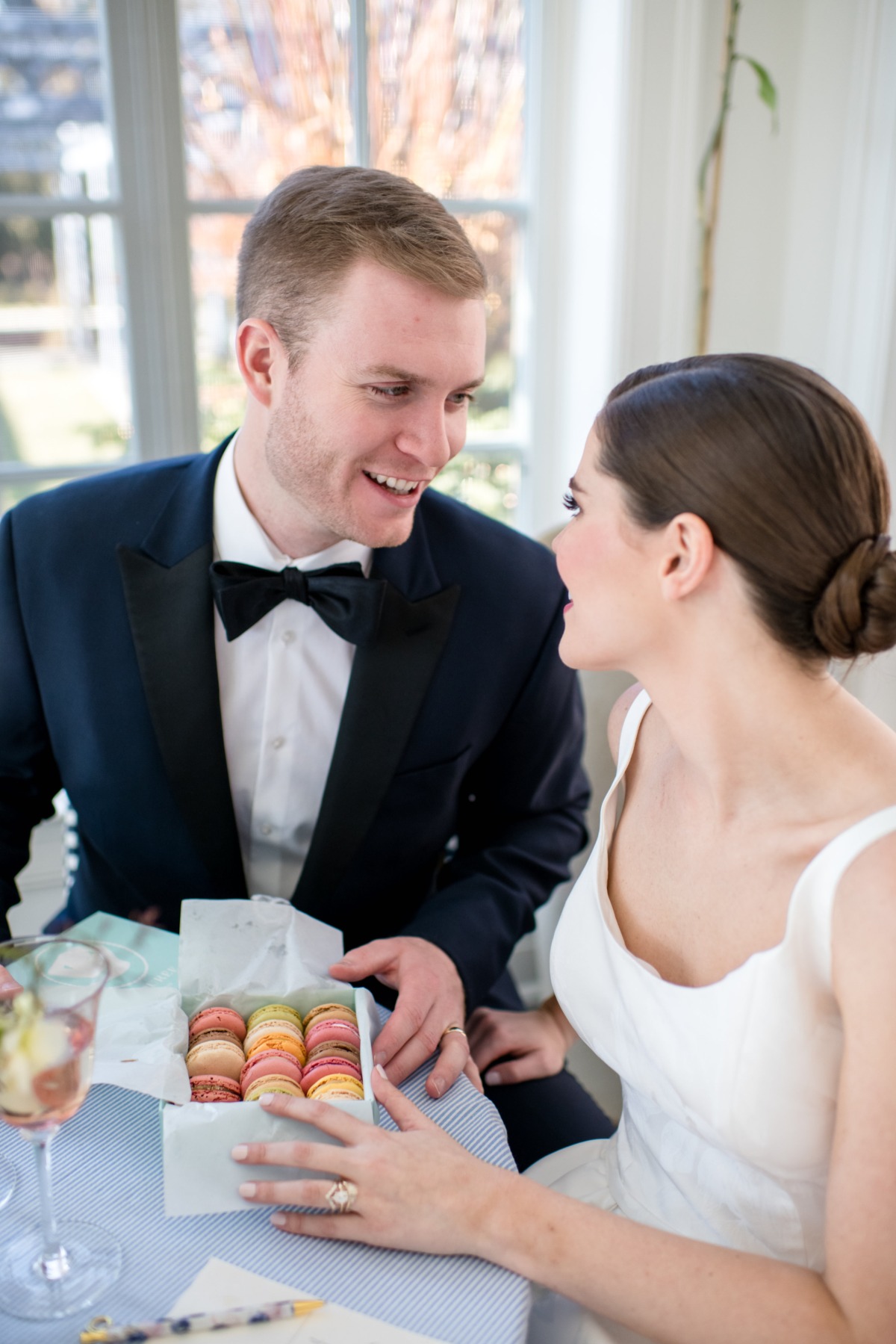 Bride and groom sharing macarons at a wedding reception