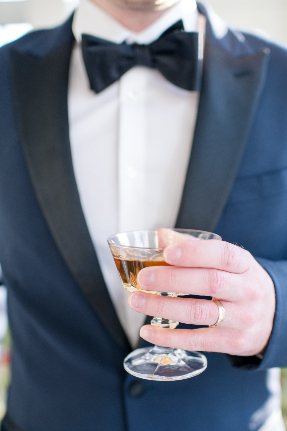 Man in a tuxedo holding a cocktail, celebrating a special event