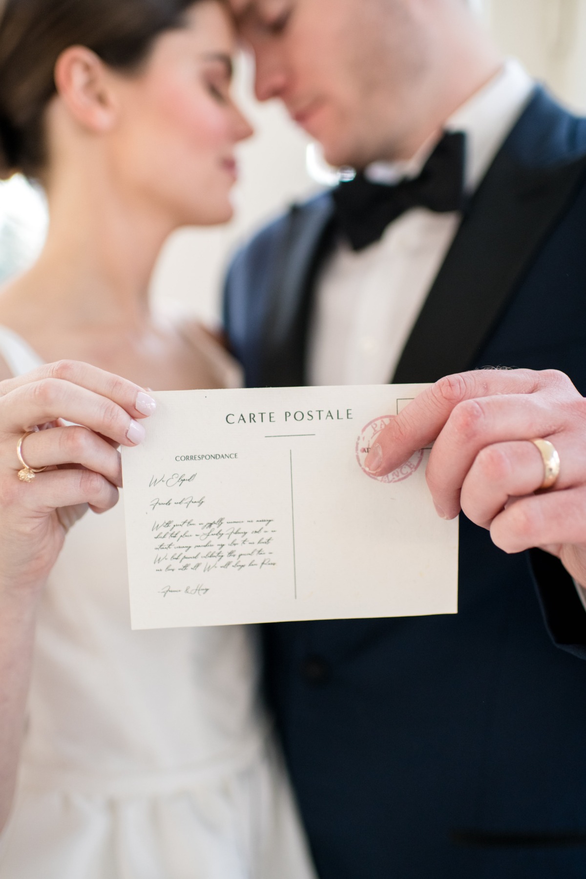 Bride and groom holding a wedding postcard invitation