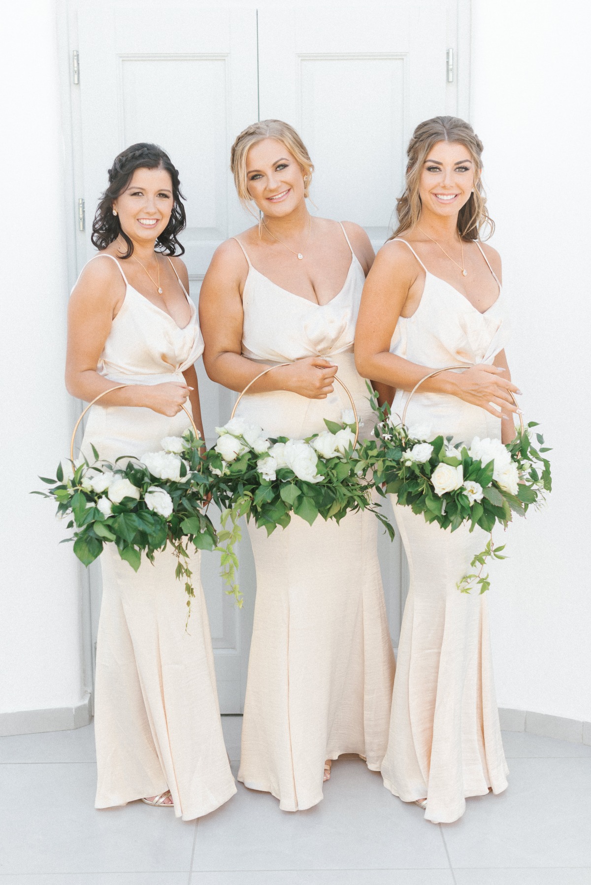 bridesmaids holding circle hoop floral arrangements