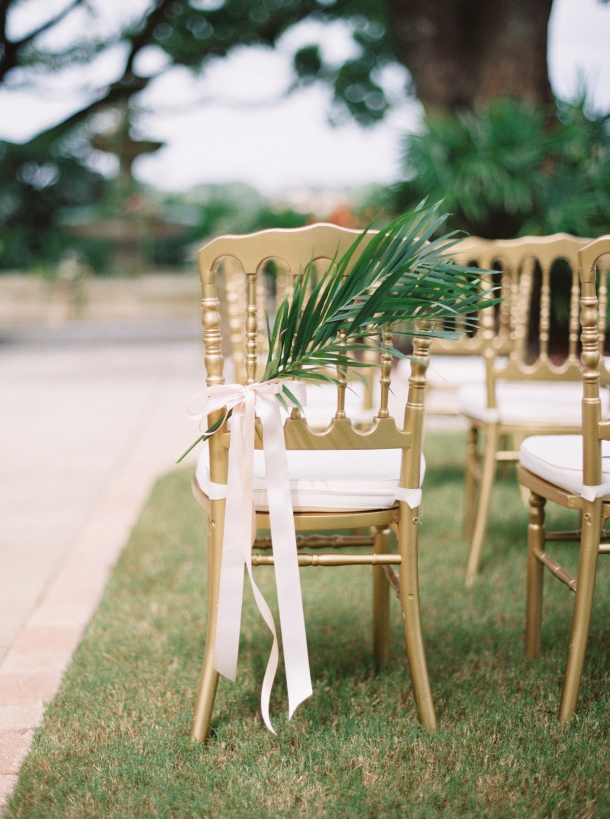 gold chair with palm leaf tied to it