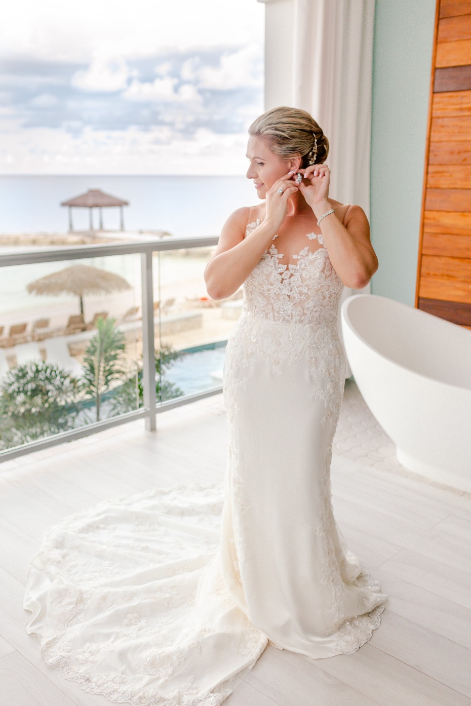 Bride puts on earring getting ready for tropical wedding