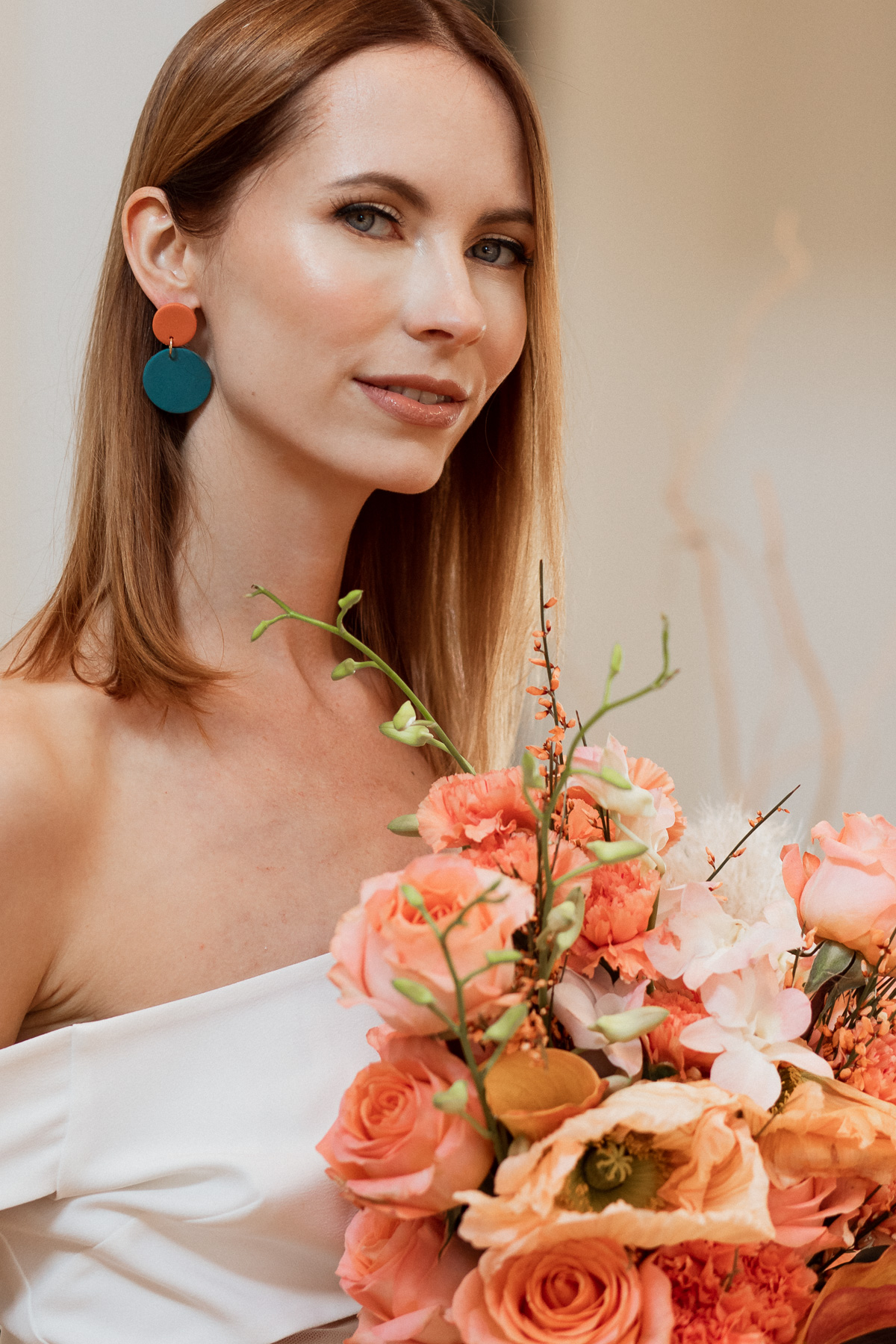 Woman with flowers and earrings in bridal style photoshoot