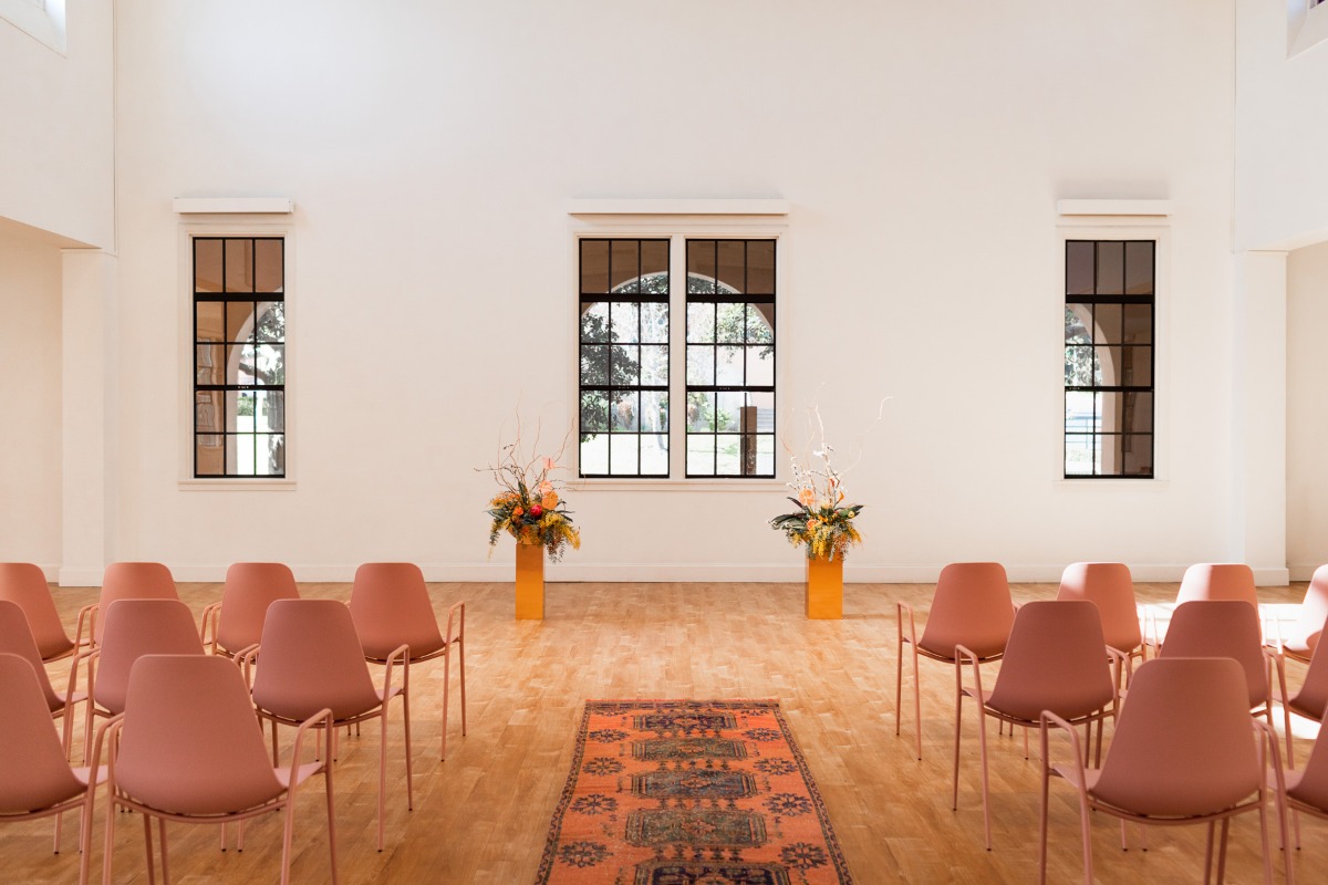 Ceremony room with chairs flowers and rug
