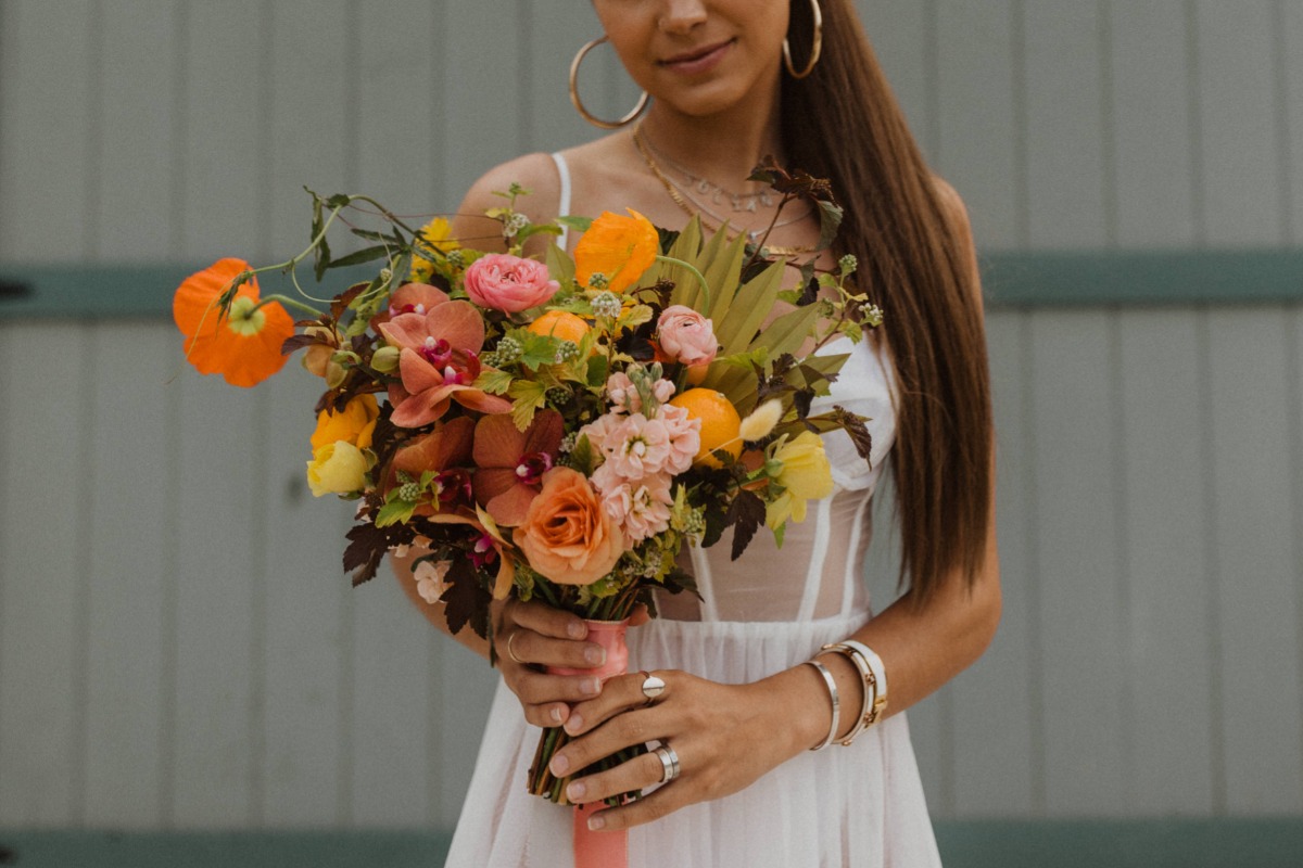 colorful wedding bouquet with orchids, oranges, garden roses