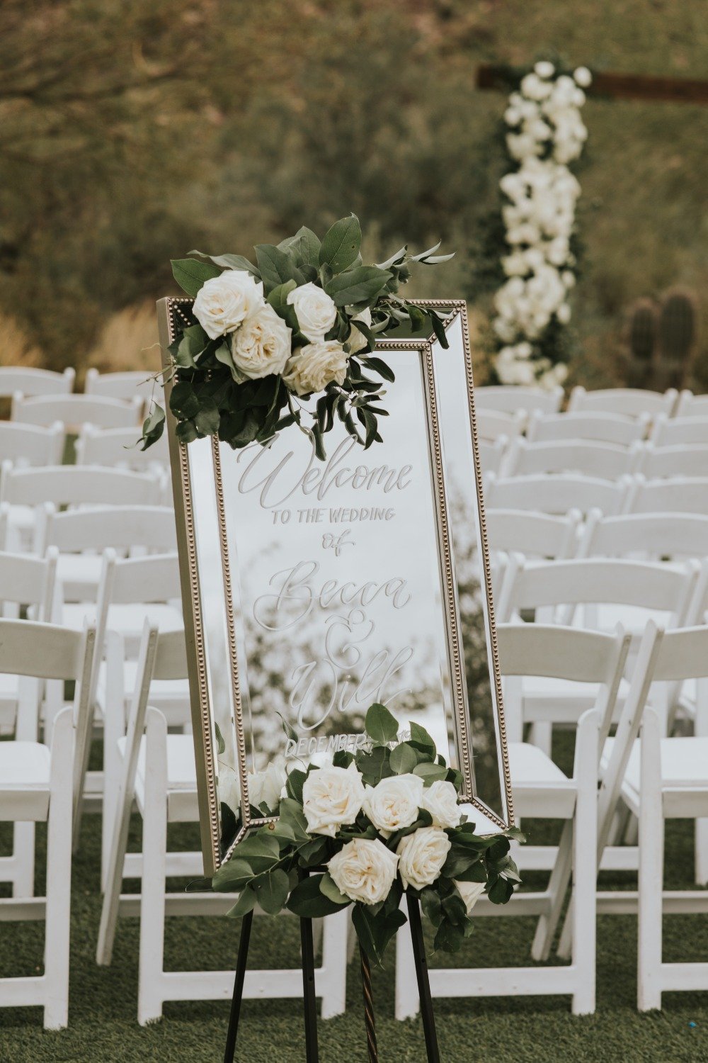 Mirror wedding sign adorned with florals