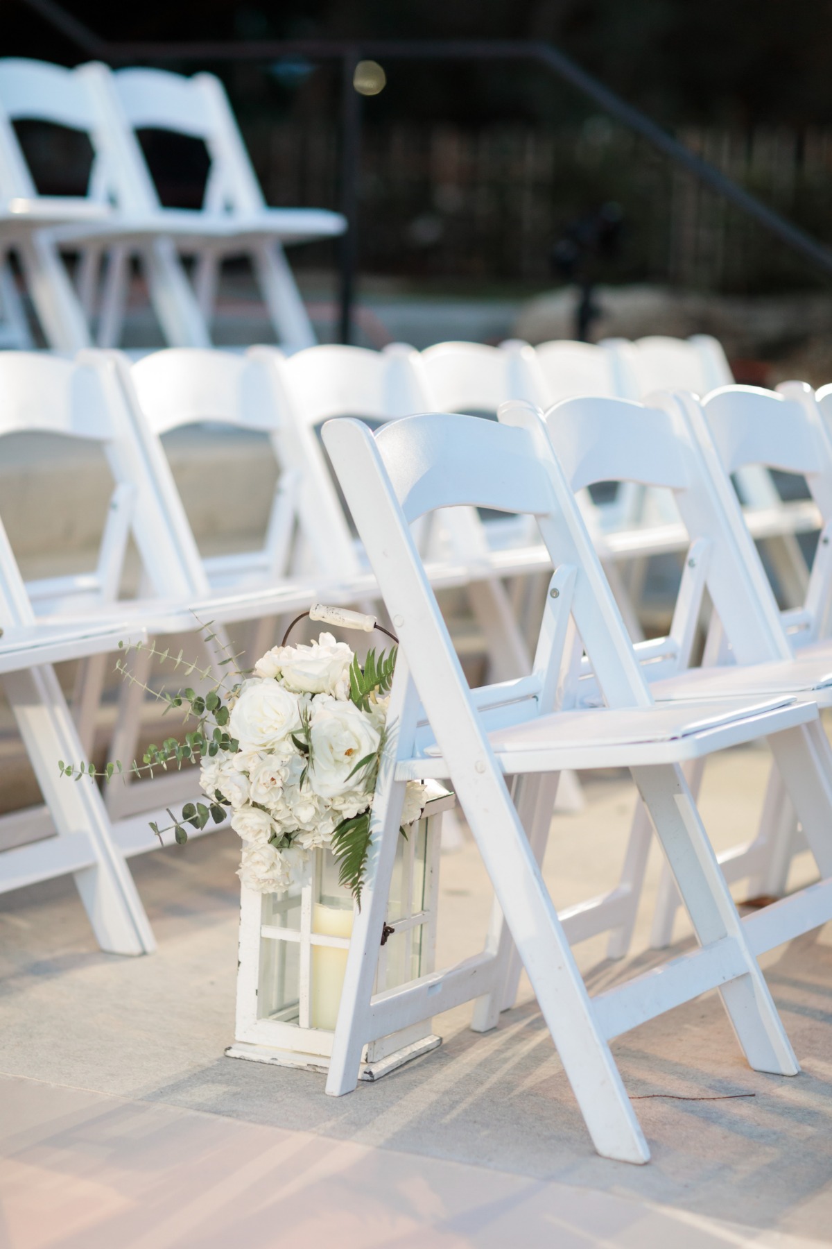 white florals on lanterns for wedding aisle decor