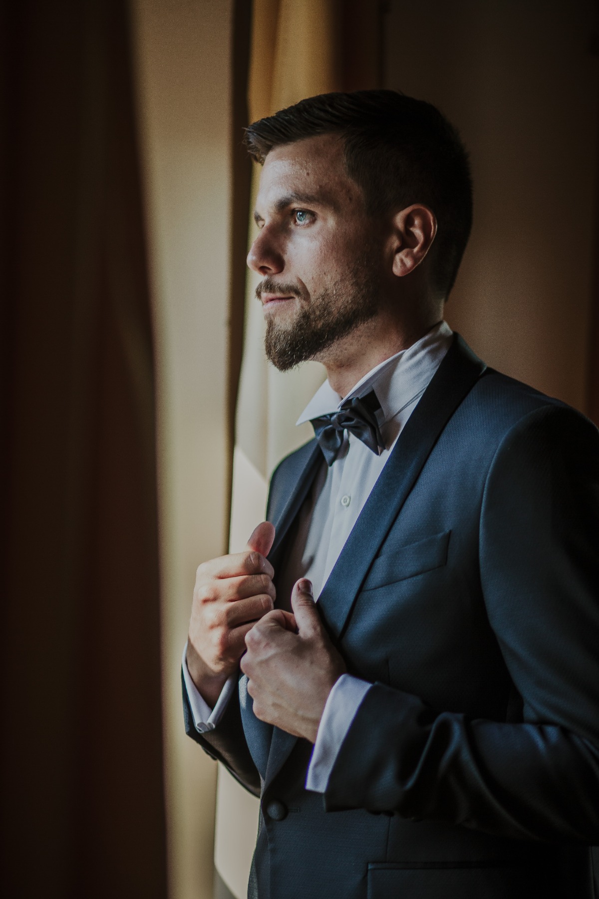 Groom in navy blue tux with black bow tie
