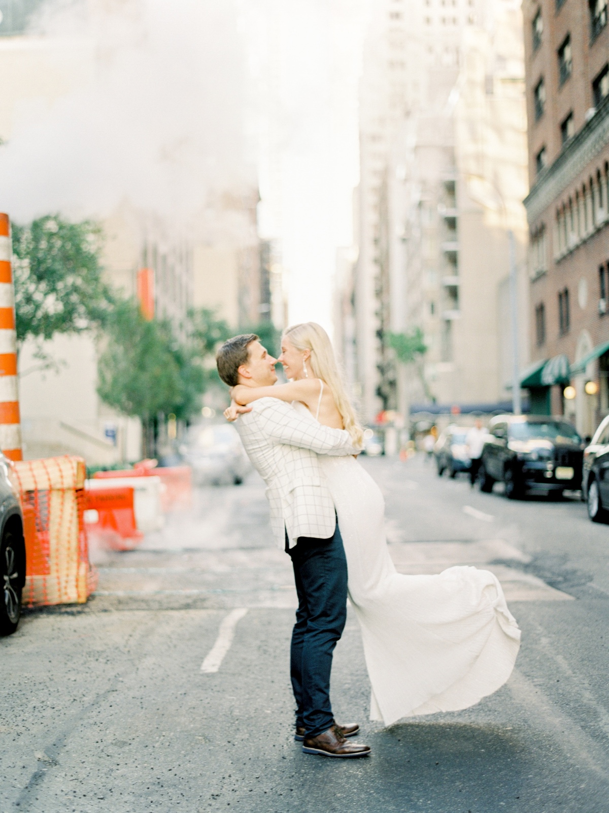 Romantic couple embraces in street with city backdrop, happiness