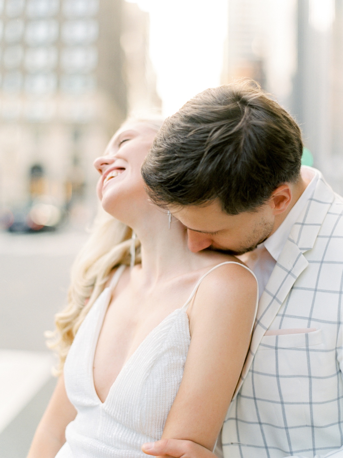 Loving couple embraces with a tender kiss on the neck, in an urban setting