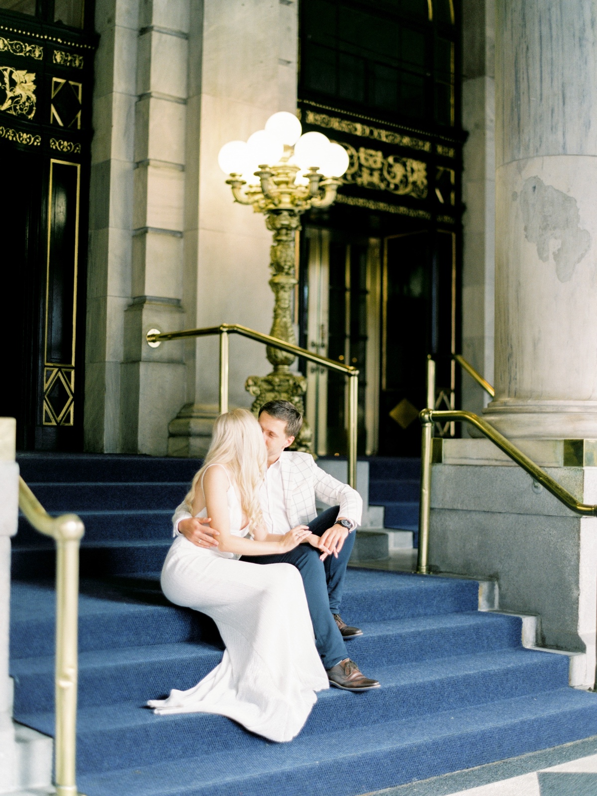 Romantic couple embracing on blue steps in front of building