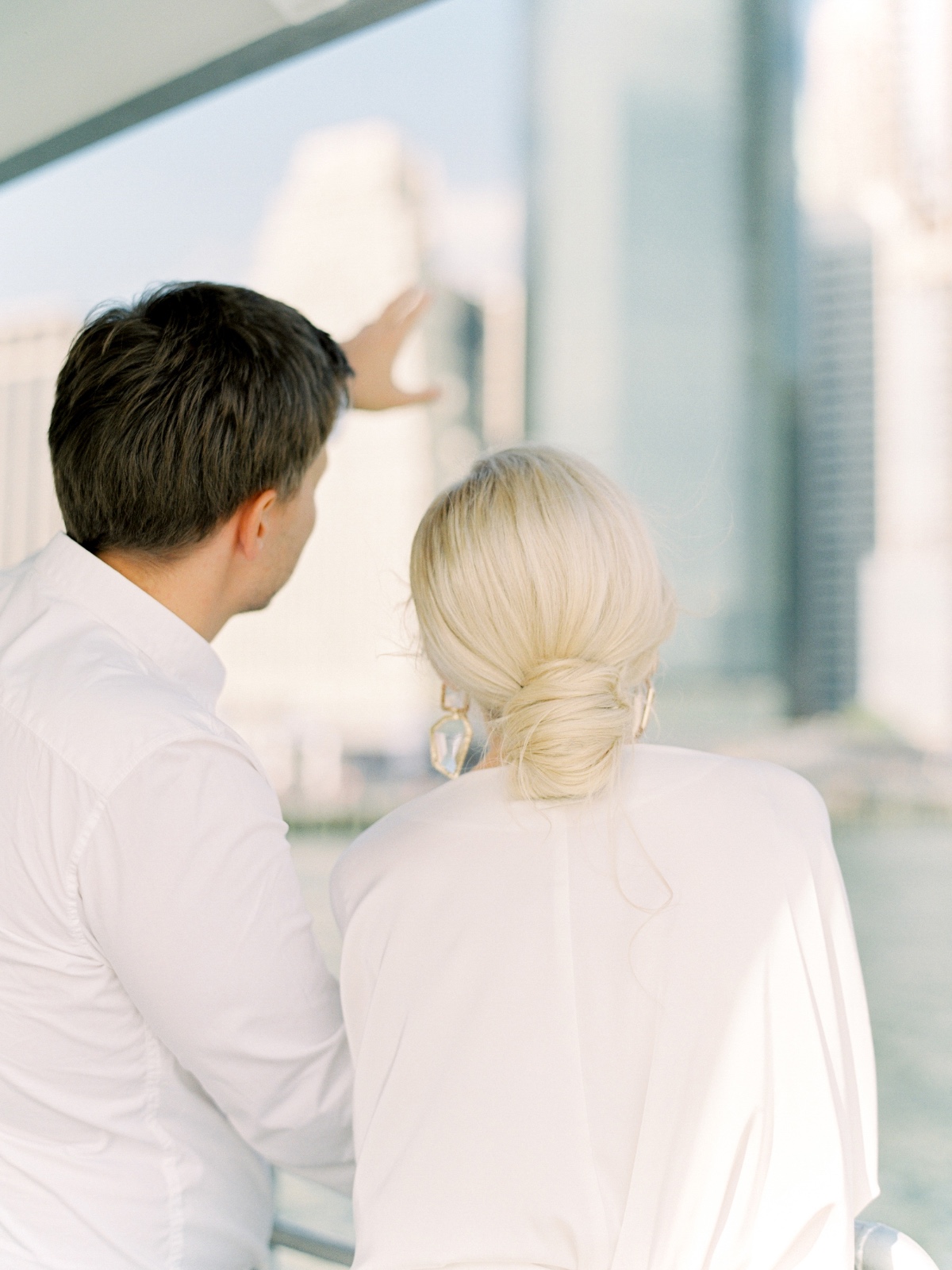 Couple admiring the cityscape view from a building, wearing white shirts