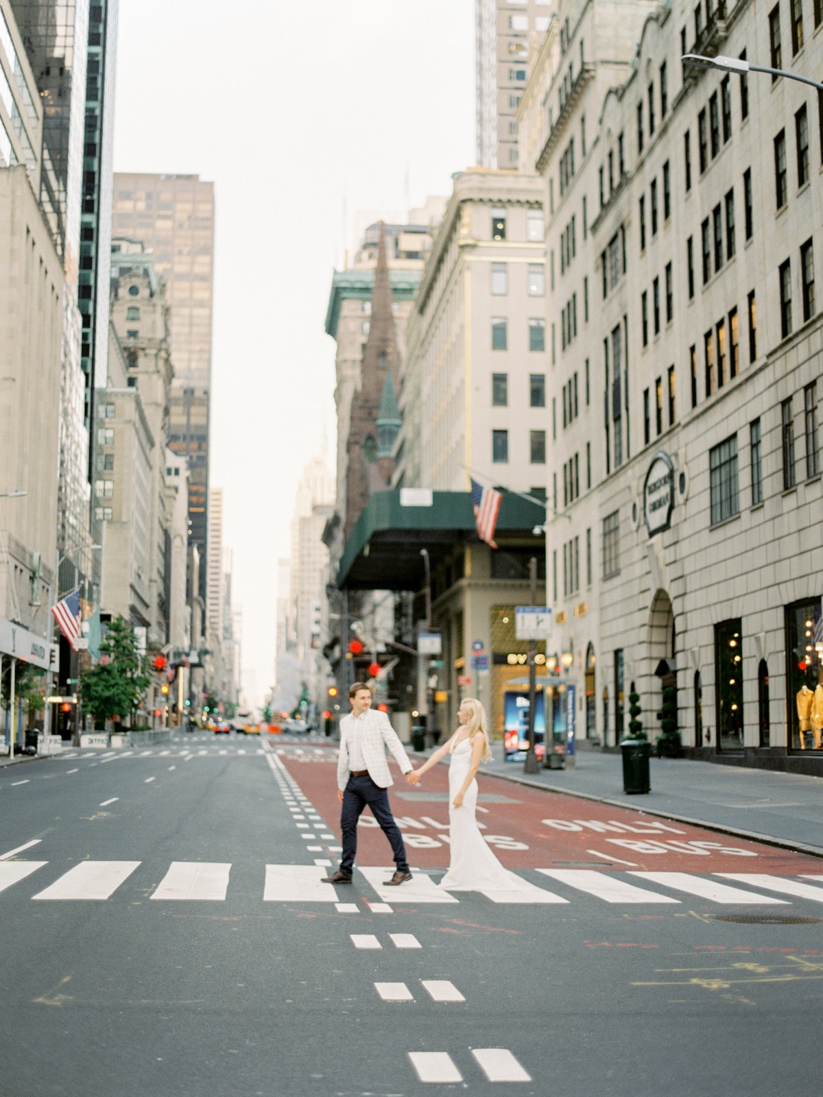 Couple holding hands crossing street in New York City