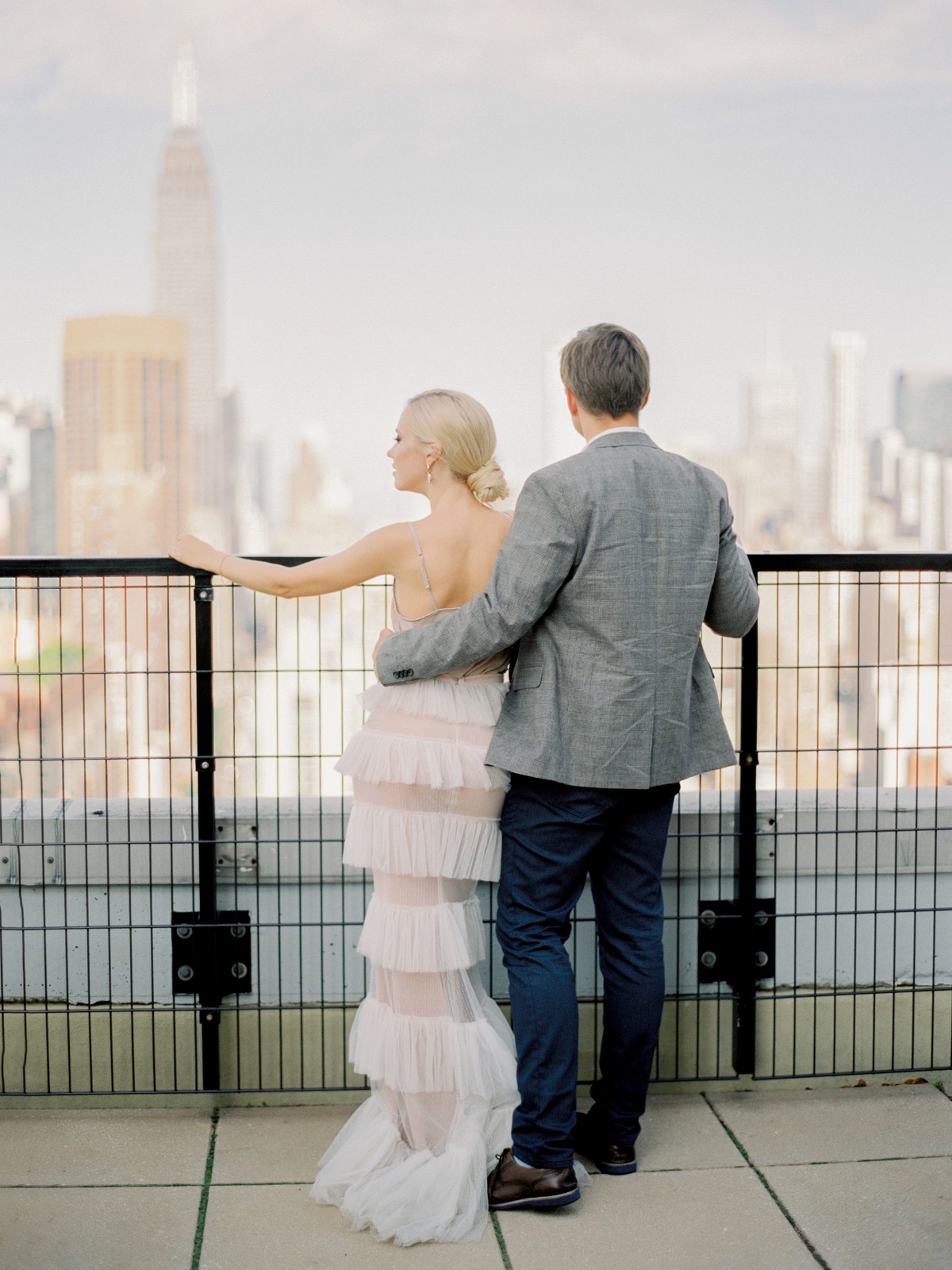 Couple on rooftop admires New York City skyline view