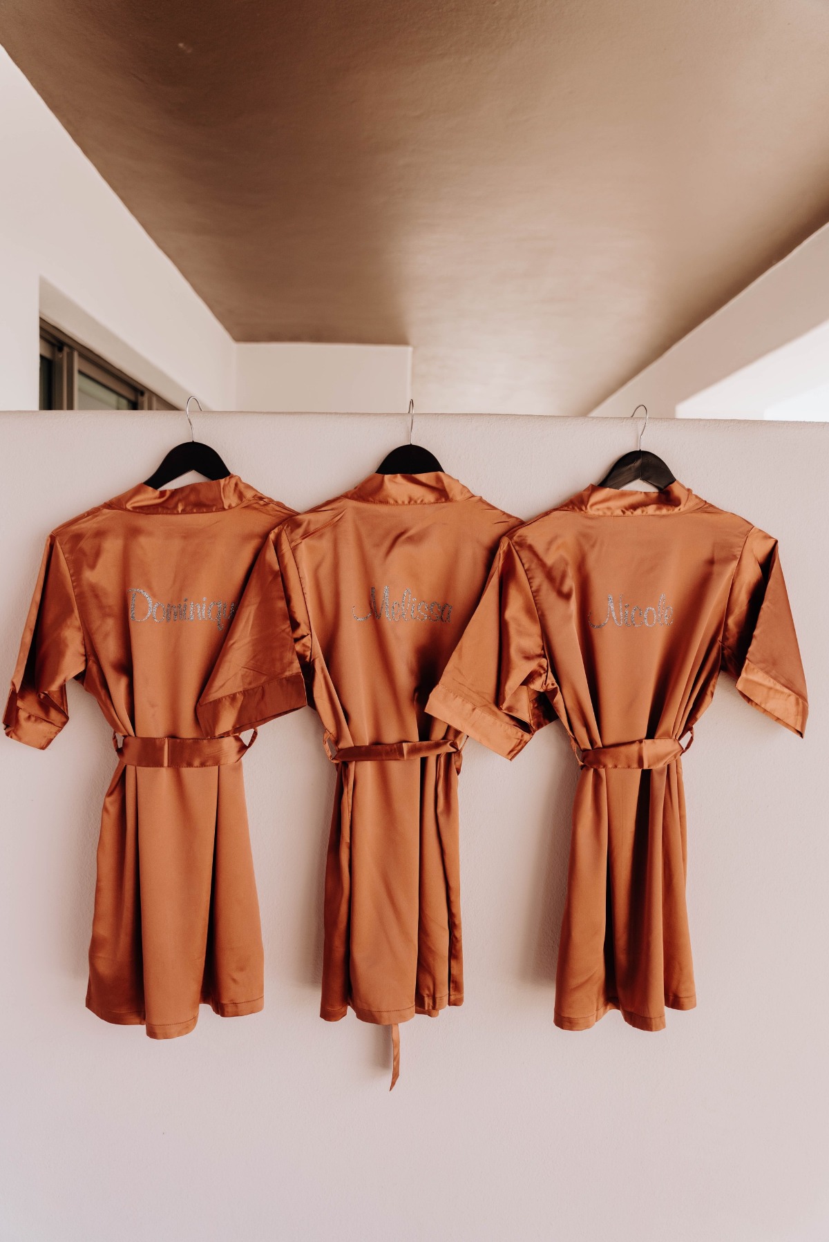 personalized terra cotta bridesmaid robes with their names in glitter.
