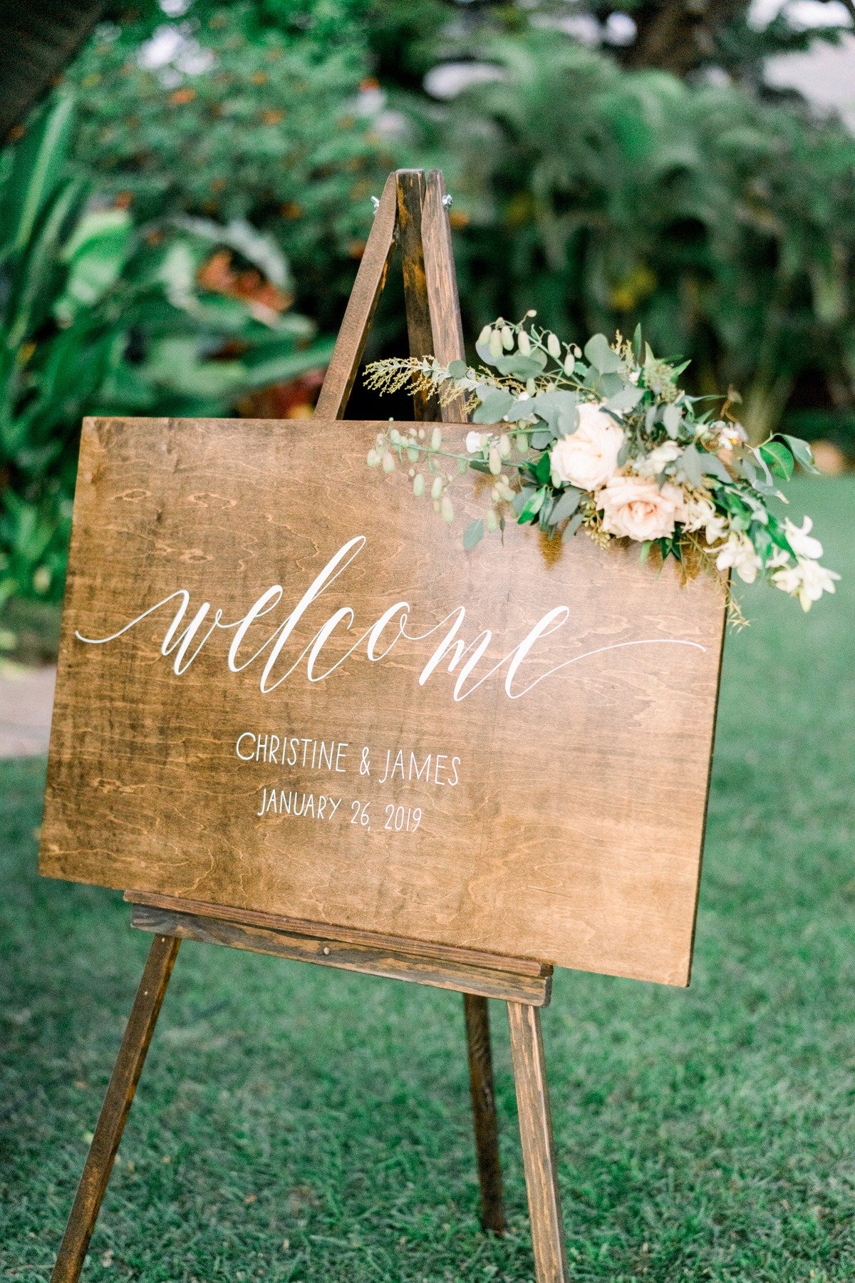 wooden welcome wedding sign adorned with flowers