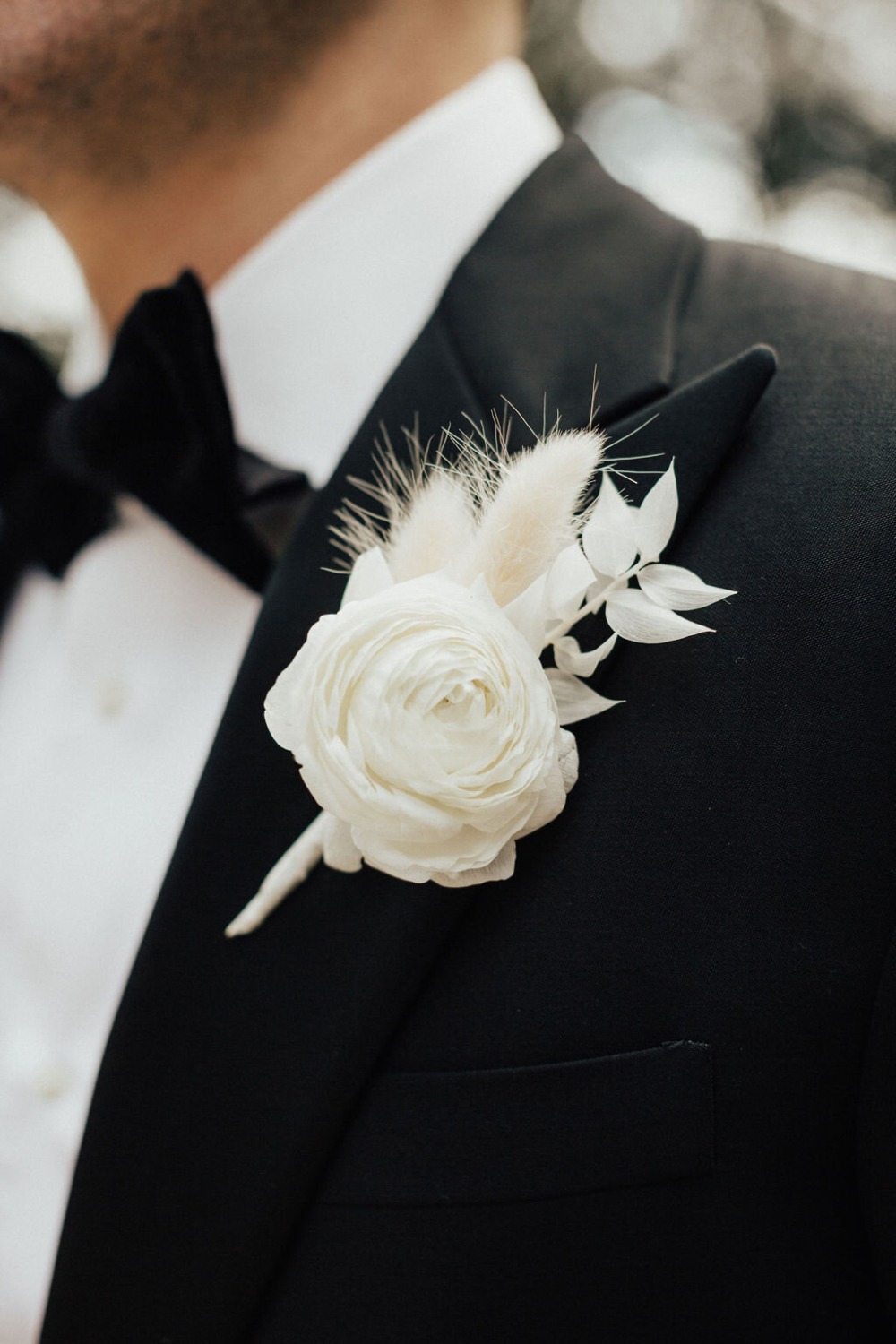 groom in black tux with white boutonniÃ¨re
