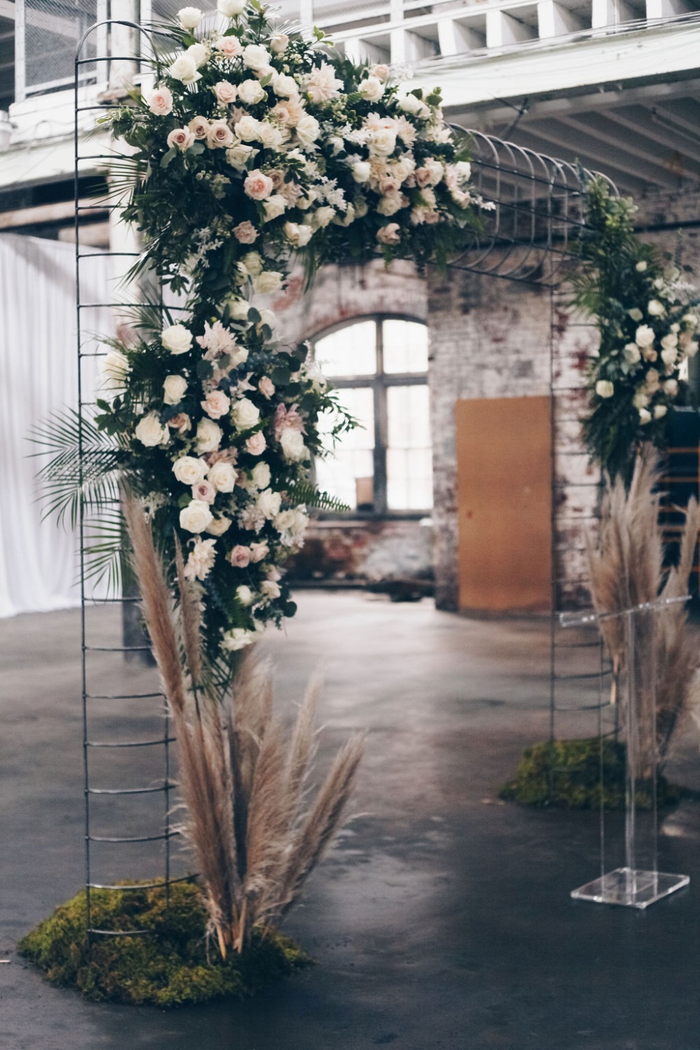 Industrial wedding ceremony floral backdrop