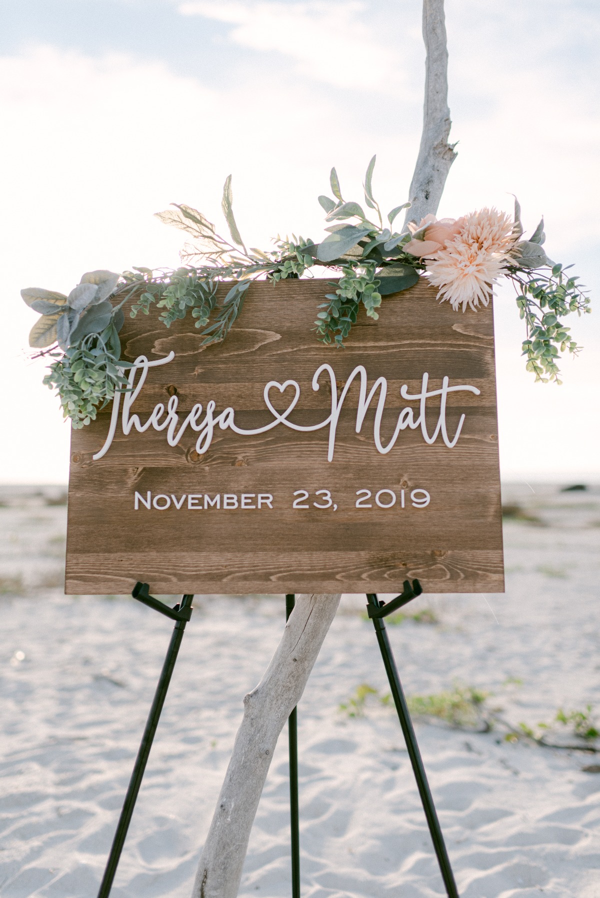 wooden wedding sign adorned with florals