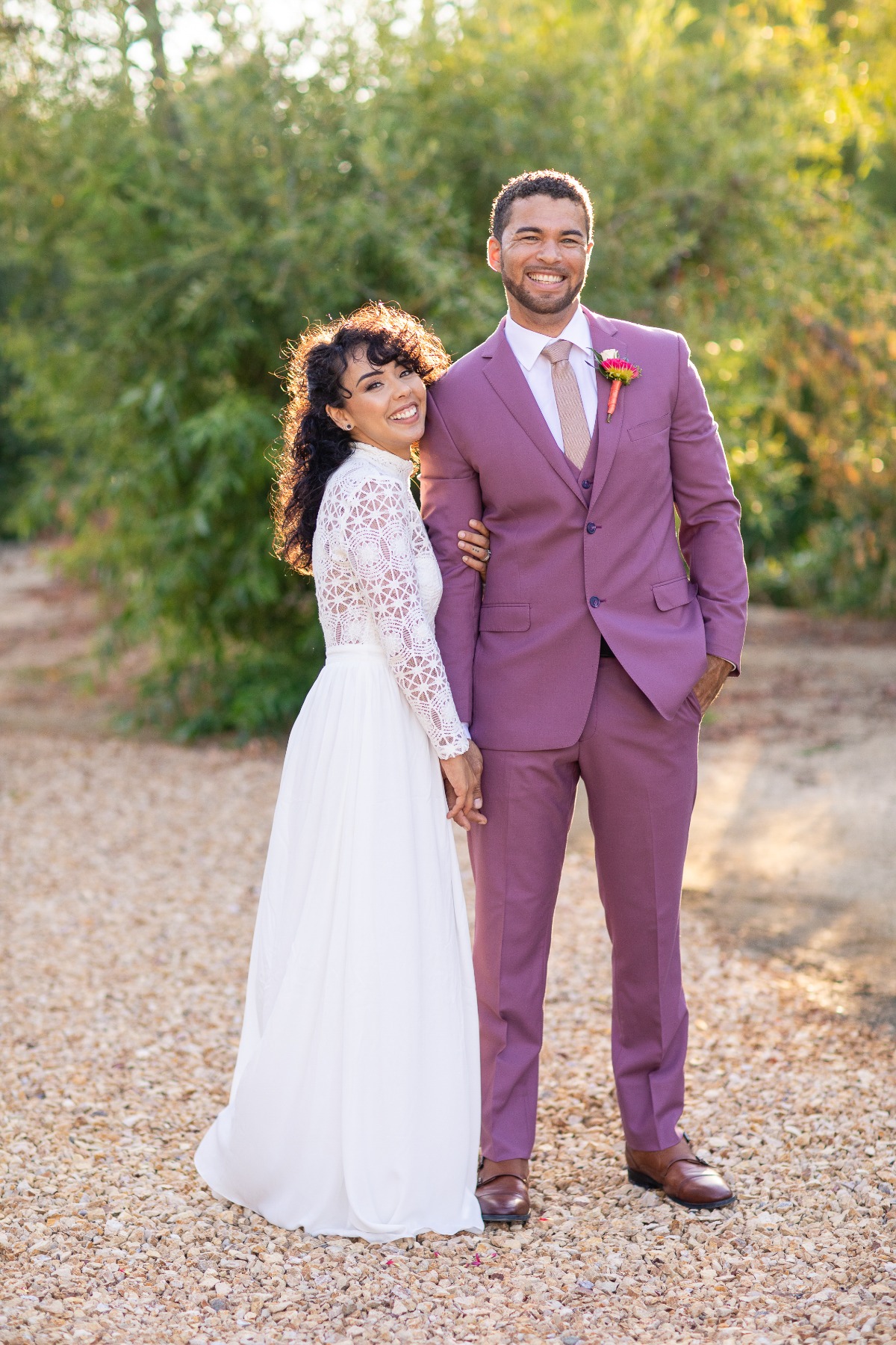 groom in pink suit and bride in long sleeve dress
