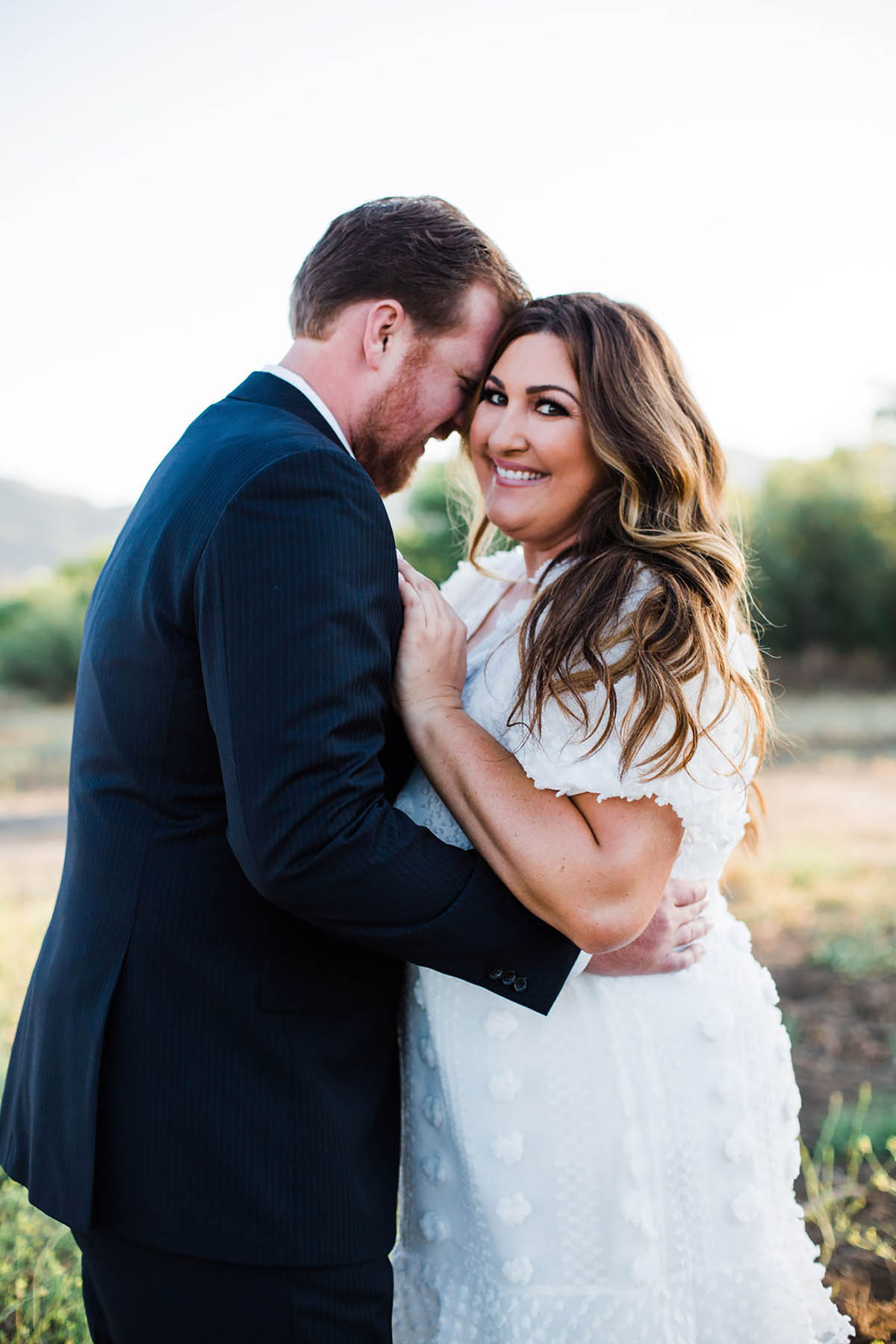 Happy bride and groom embracing outdoors on wedding day