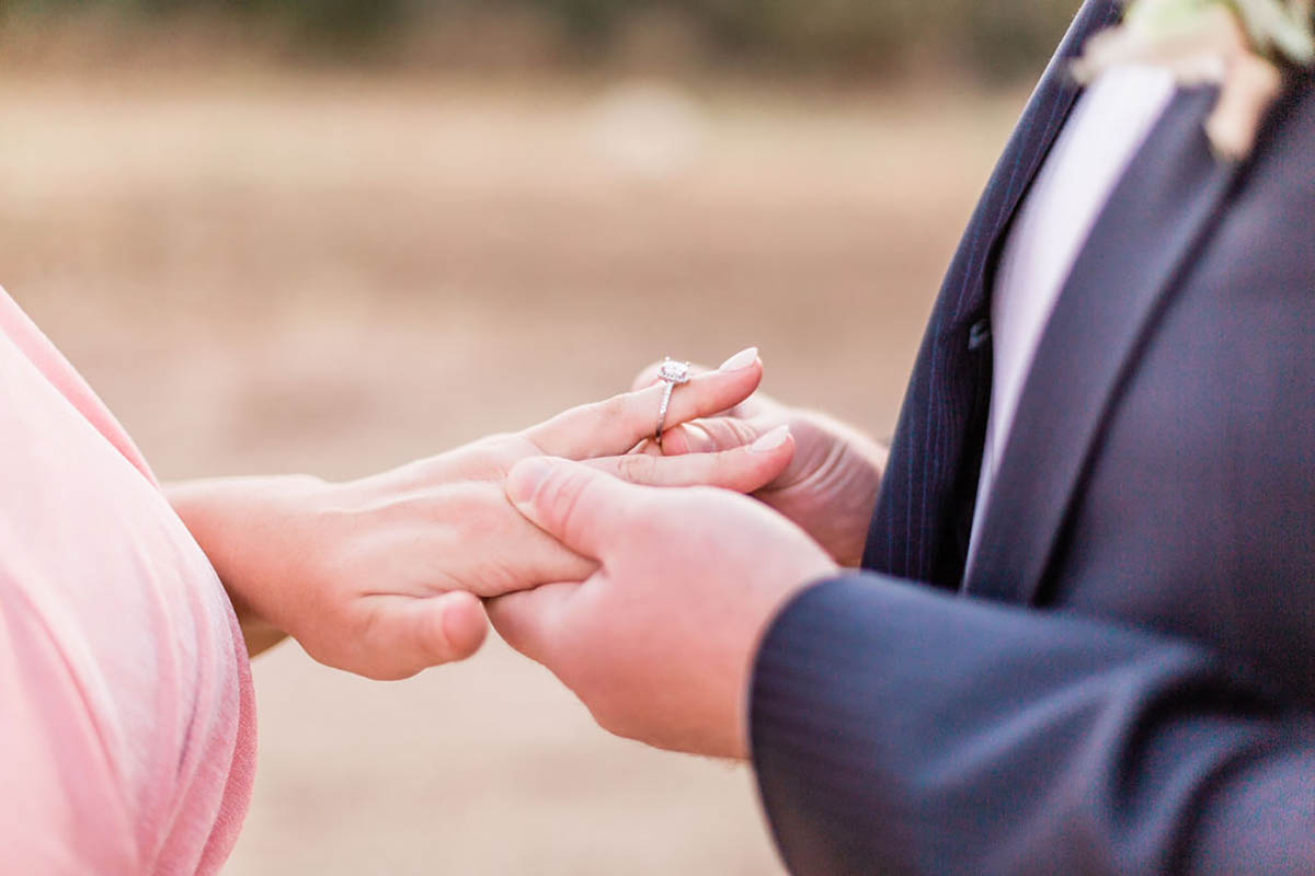 Engagement ring placed on bride to bes finger