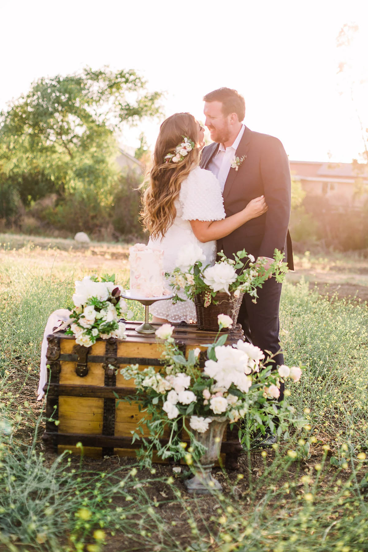 Bride and groom outdoor wedding cake on vintage trunk