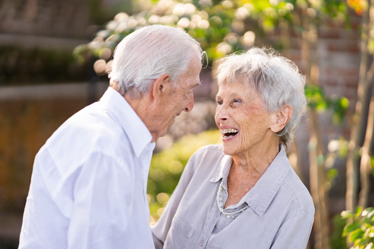 Happy elderly couple share a laugh in the garden
