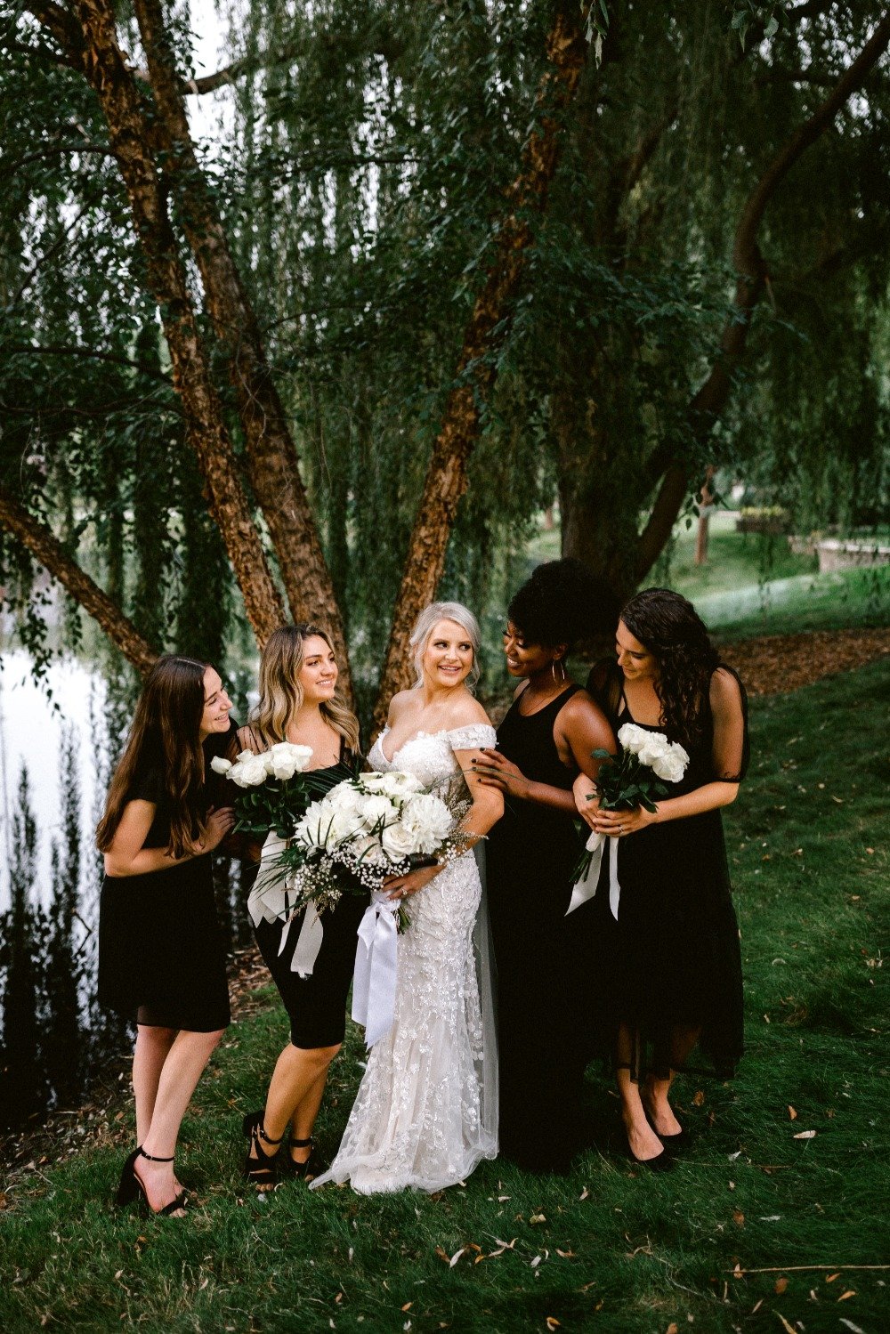 bridesmaids in mismatched black dresses paired with wedding bouquets