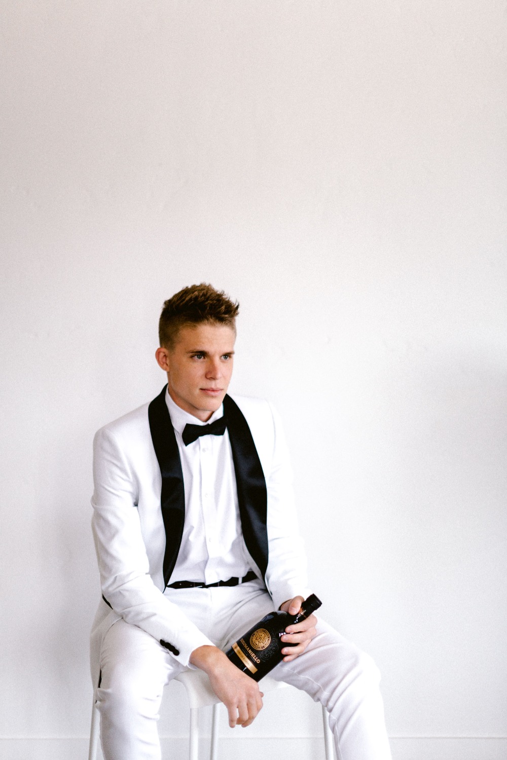 groom in white tux with black trim