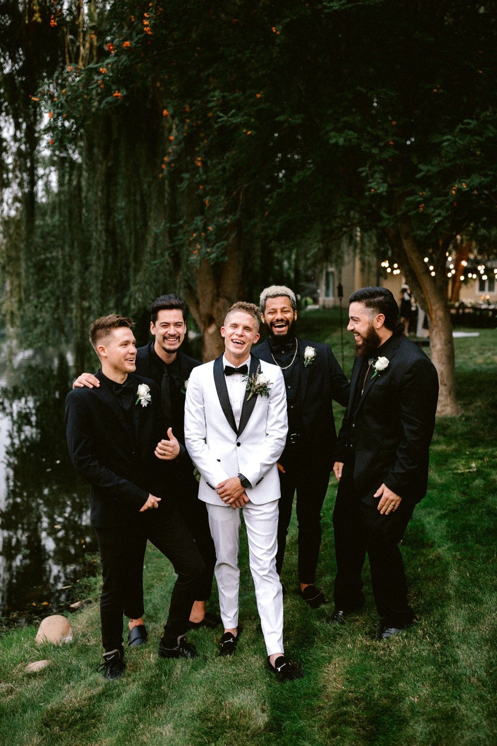 groomsmen in black and groom in white with black trim