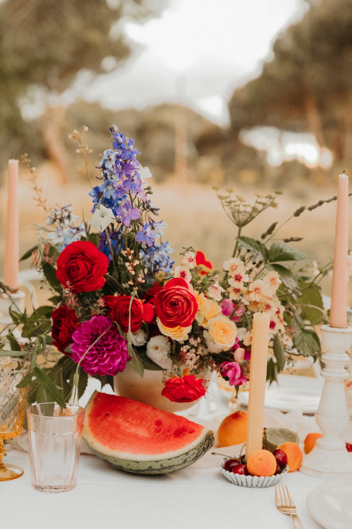 Floral arrangement and watermelon on a table outdoors