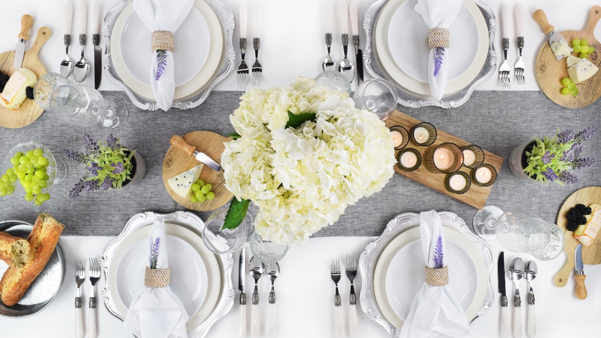 Elegant table setting with hydrangeas, candles, and cheese