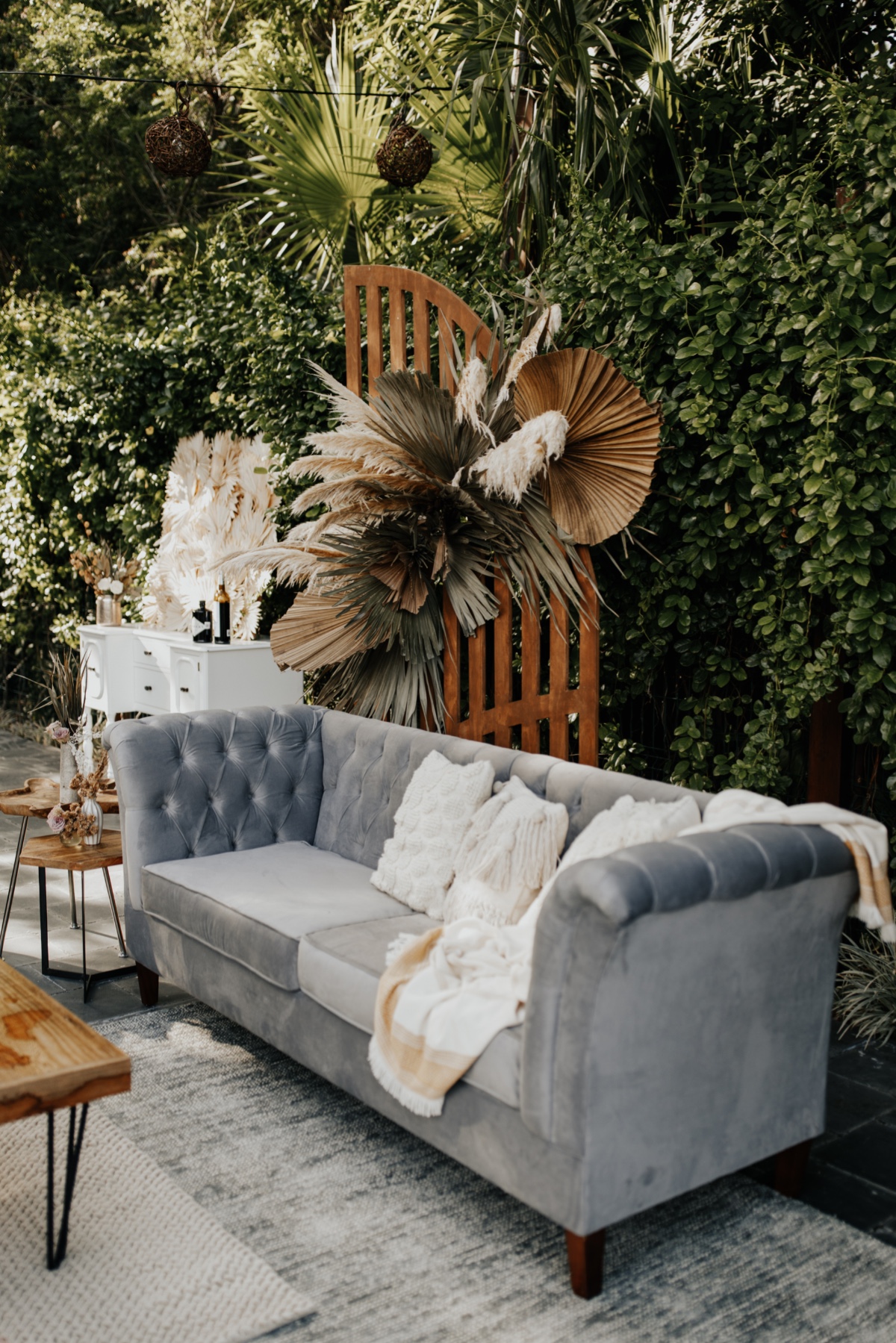 Outdoor seating area with gray sofa and bohemian decor
