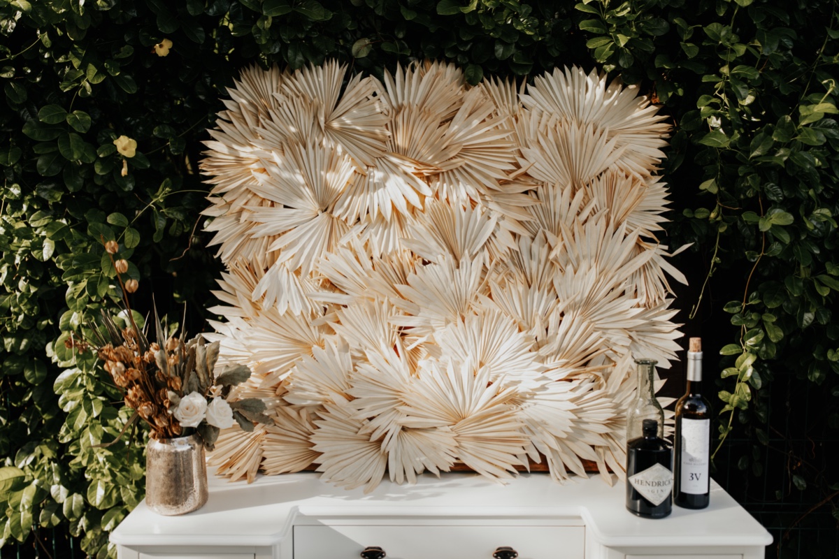 Drinks on a white table with a dried palm leaf backdrop