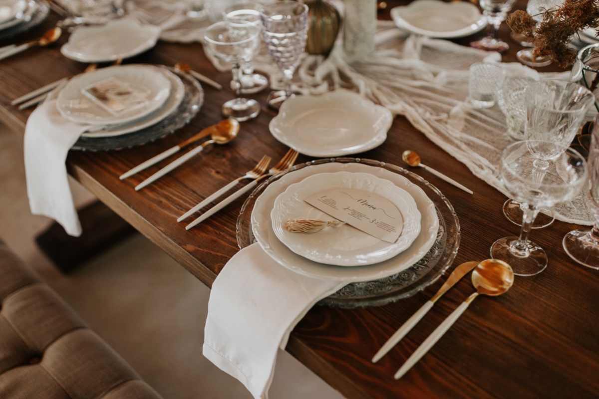Elegant wedding table setting with gold cutlery and menu