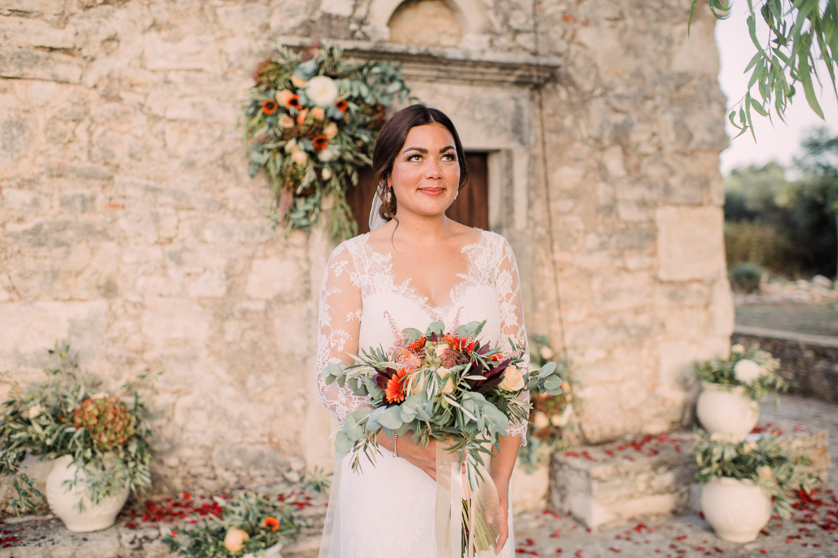 Bride holds bouquet at a stone chapel wedding venue