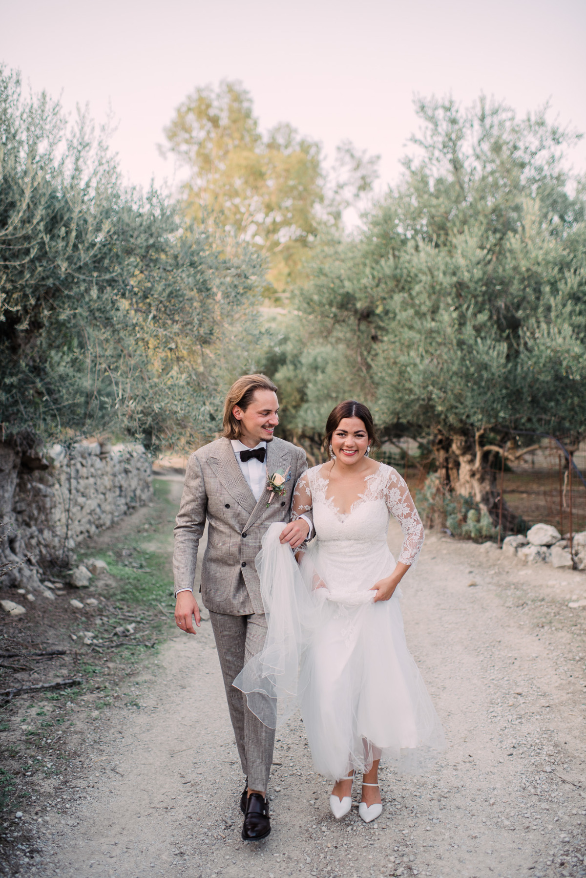 Happy bride and groom walking down a path