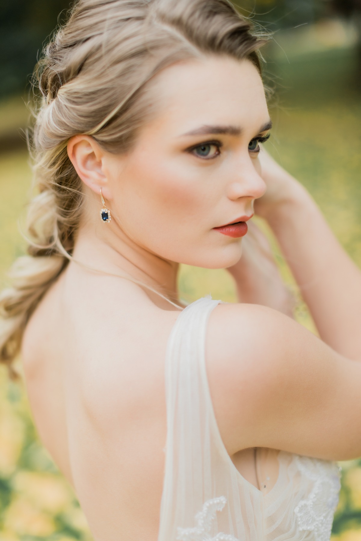 Elegant bride with braided hair and sapphire earrings