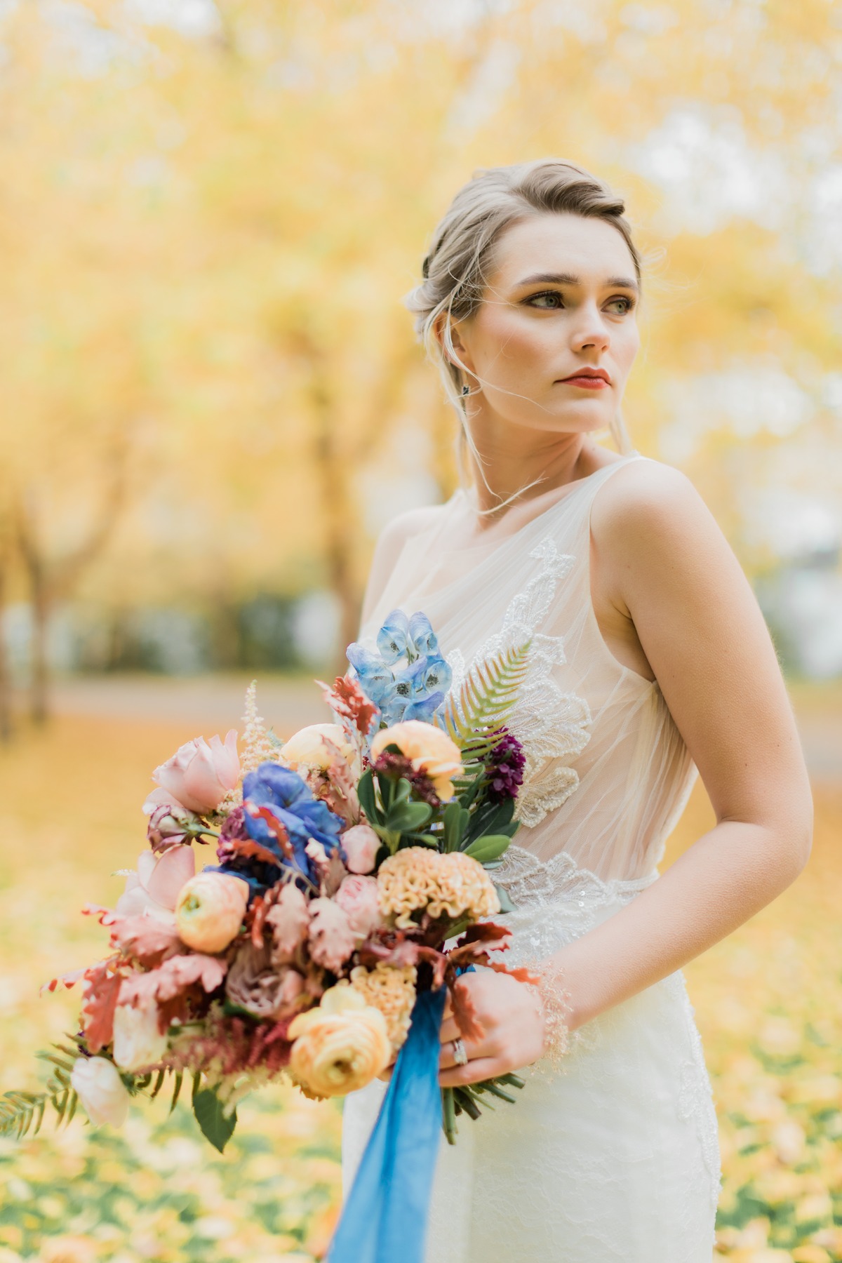 Bride with colorful fall bouquet and lace wedding dress