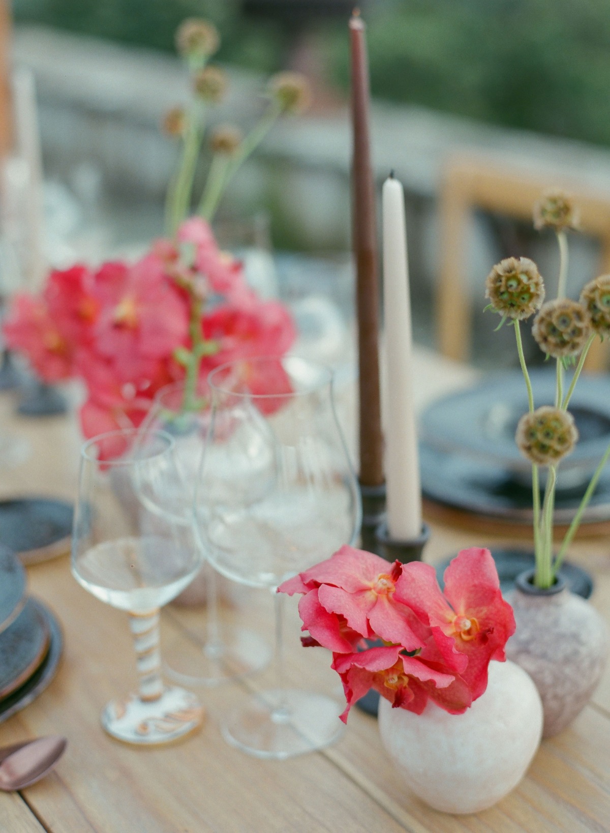 Elegant table setting with red flowers and wine glasses