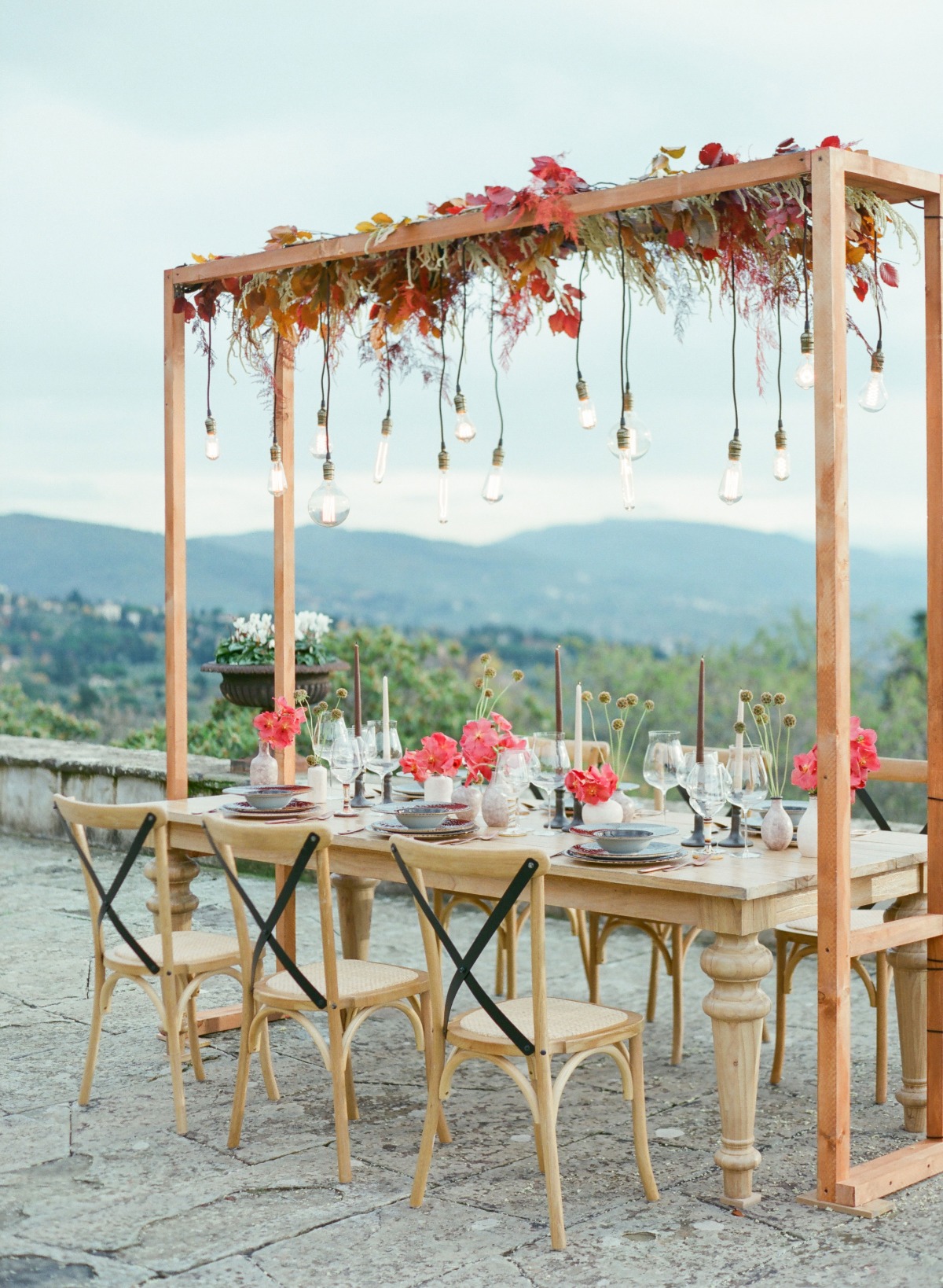 Elegant outdoor dining table decorated with flowers and lights