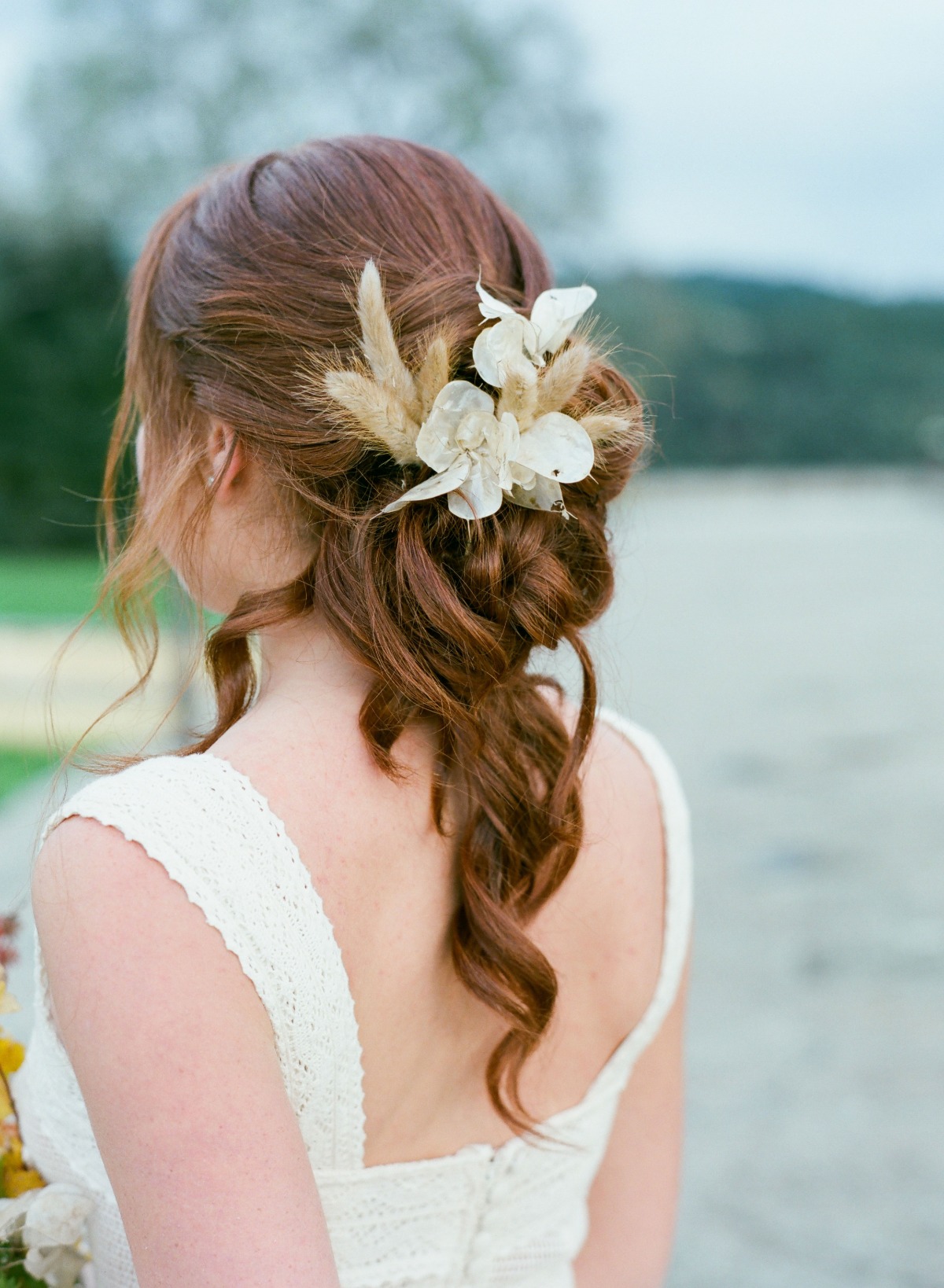 Elegant bridal updo with dried flowers in her hair