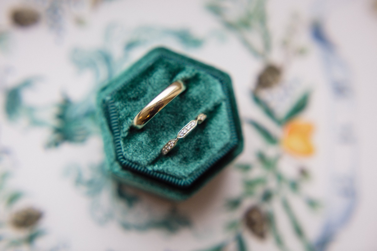 Wedding rings in a velvet ring box, floral background