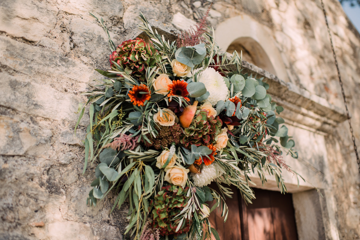 Autumnal wedding floral arrangement on stone wall