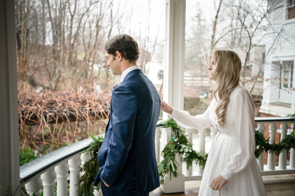 Bride touching the groom on shoulder before wedding ceremony